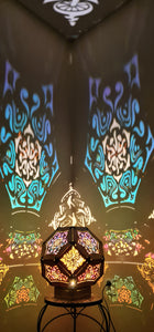 Illuminated kaleidoscope-style shadow lamp with a geometric mushroom design projecting colorful patterns on walls and ceiling.