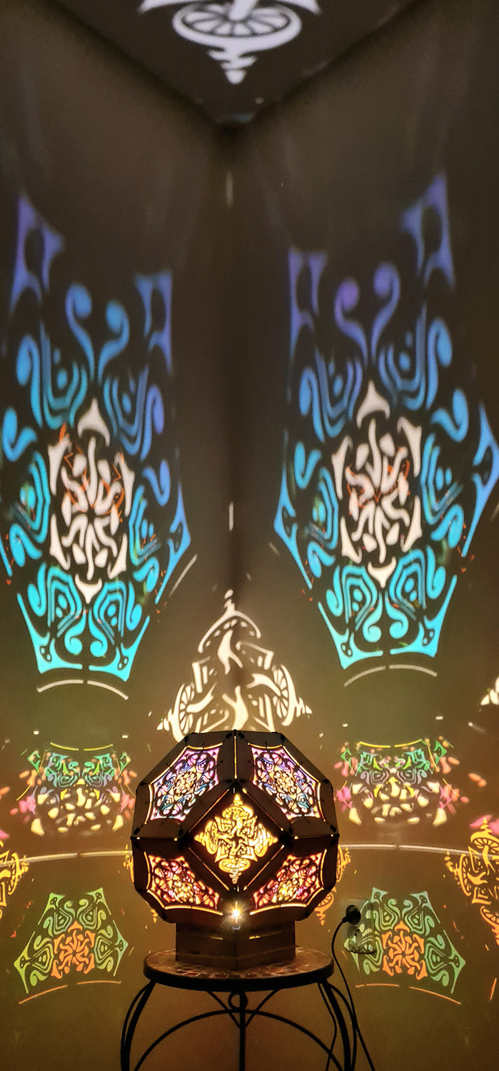 Illuminated kaleidoscope-style shadow lamp with a geometric mushroom design projecting colorful patterns on walls and ceiling.