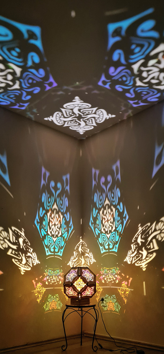 Illuminated kaleidoscope-style shadow lamp with a geometric mushroom design projecting colorful patterns on walls and ceiling.