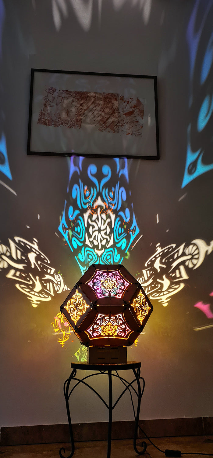 Illuminated kaleidoscope-style shadow lamp with a geometric mushroom design projecting colorful patterns on walls and ceiling.