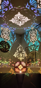 Illuminated kaleidoscope-style shadow lamp with a geometric mushroom design projecting colorful patterns on walls and ceiling.