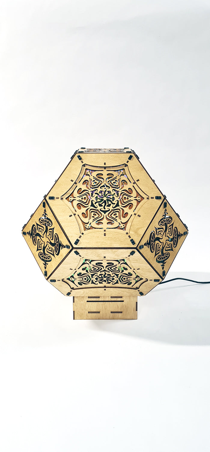 Illuminated kaleidoscope-style shadow lamp with a geometric mushroom design projecting colorful patterns on walls and ceiling.