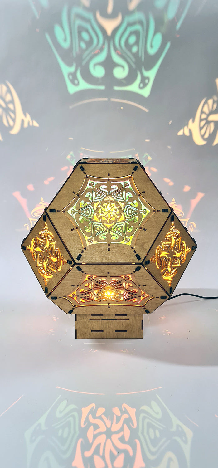 Illuminated kaleidoscope-style shadow lamp with a geometric mushroom design projecting colorful patterns on walls and ceiling.