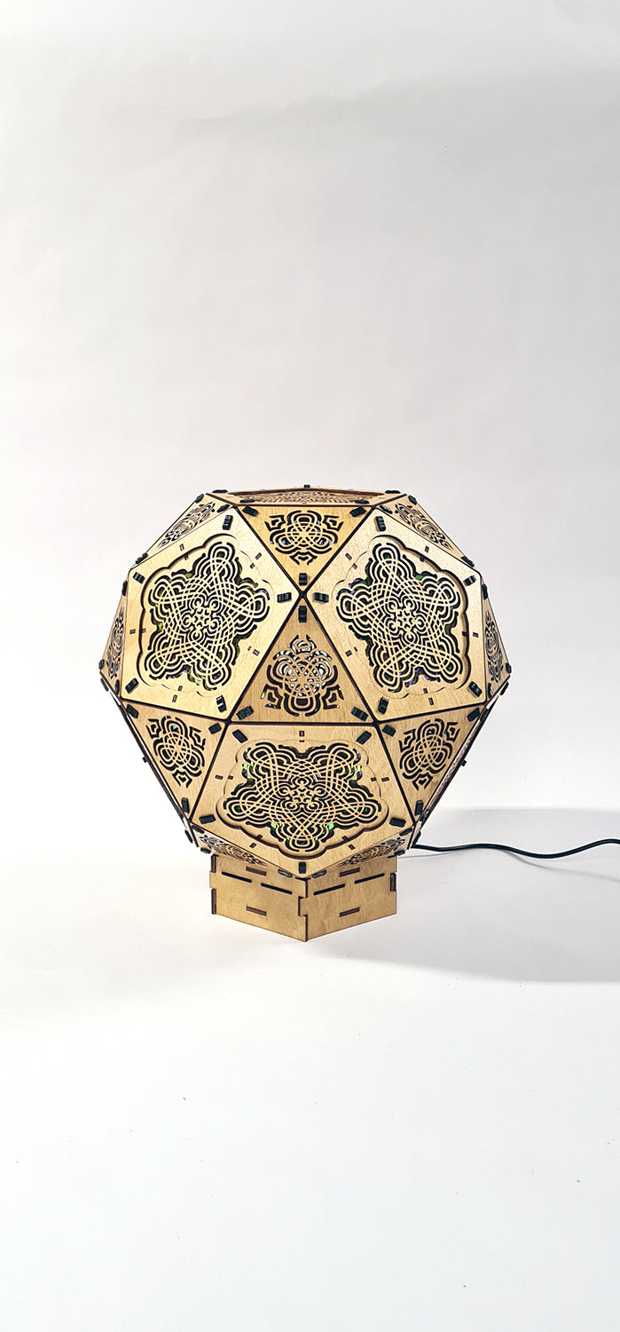 A colorful geometric patterned lamp casts shadows on a wall, with intricate designs created by the interplay of light and shadow.