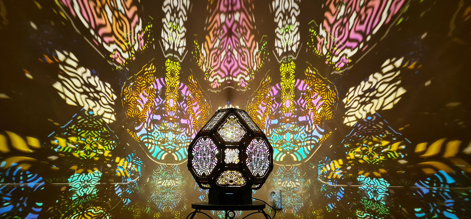 A colorful shadow lamp projecting intricate geometric patterns on a wall, with the lamp in the foreground.