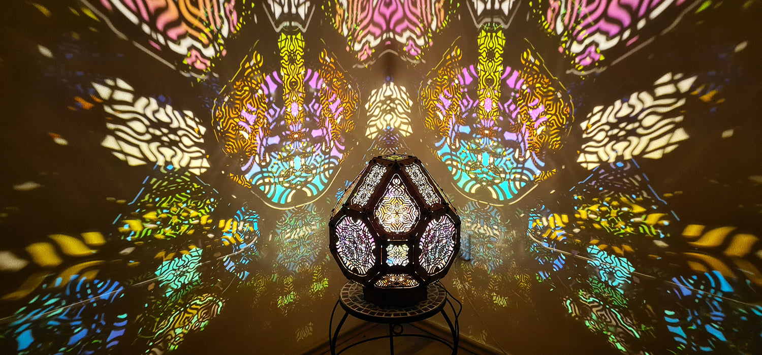 A colorful shadow lamp projecting intricate geometric patterns on a wall, with the lamp in the foreground.