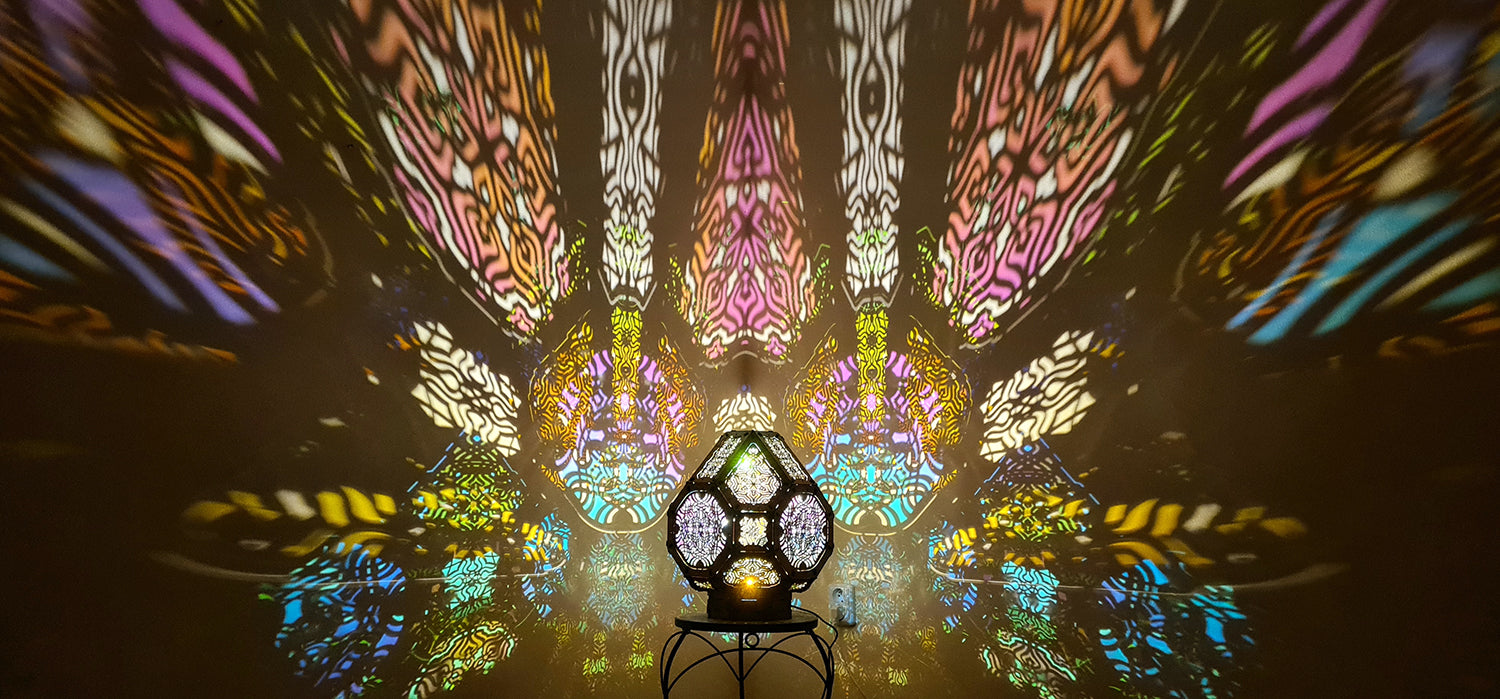 A colorful shadow lamp projecting intricate geometric patterns on a wall, with the lamp in the foreground.