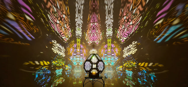 A colorful shadow lamp projecting intricate geometric patterns on a wall, with the lamp in the foreground.