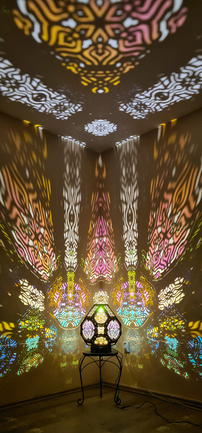 A colorful shadow lamp projecting intricate geometric patterns on a wall, with the lamp in the foreground.