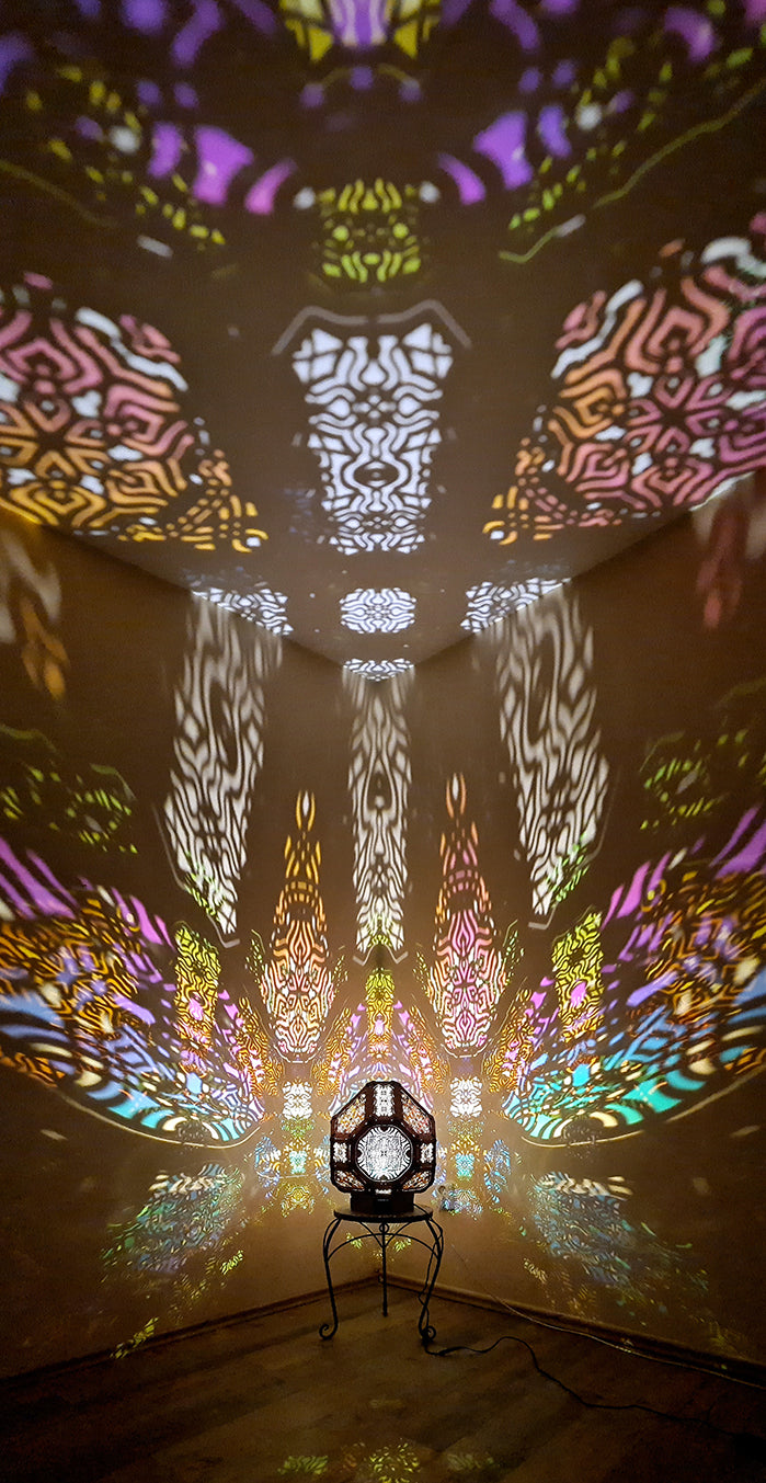 A colorful shadow lamp projecting intricate geometric patterns on a wall, with the lamp in the foreground.