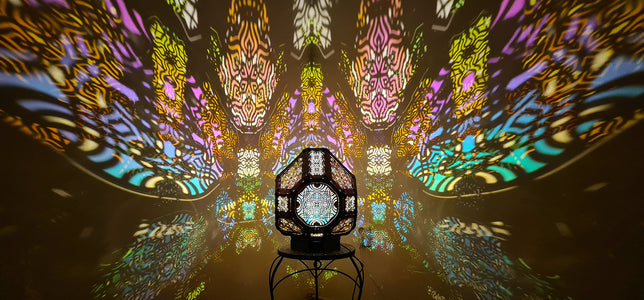A colorful shadow lamp projecting intricate geometric patterns on a wall, with the lamp in the foreground.