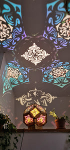 Illuminated kaleidoscope-style shadow lamp with a geometric mushroom design projecting colorful patterns on walls and ceiling.