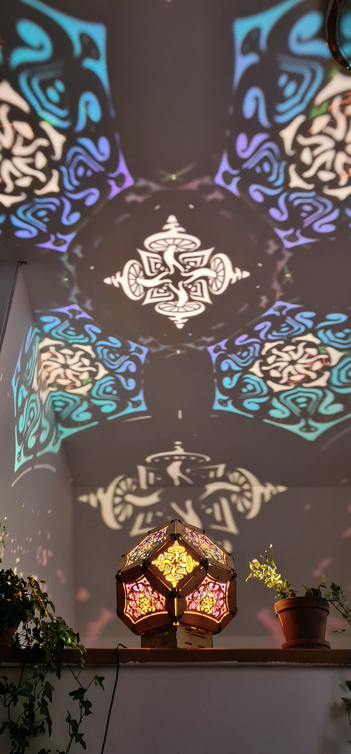 Illuminated kaleidoscope-style shadow lamp with a geometric mushroom design projecting colorful patterns on walls and ceiling.