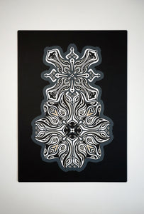 Monochrome layered paper artwork titled Metamorphs, made of intricate geometric mandalas that reveal totemic faces.