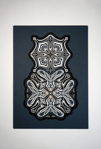 Monochrome layered paper artwork titled Metamorphs, made of intricate geometric mandalas that reveal totemic faces.