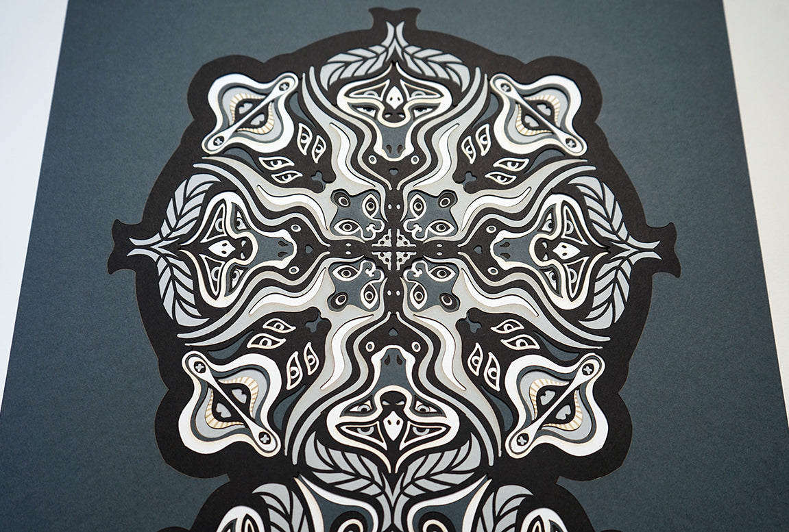 Monochrome layered paper artwork from the Metamorphs series, featuring interlocking mandalas that form hidden animal and spirit faces.