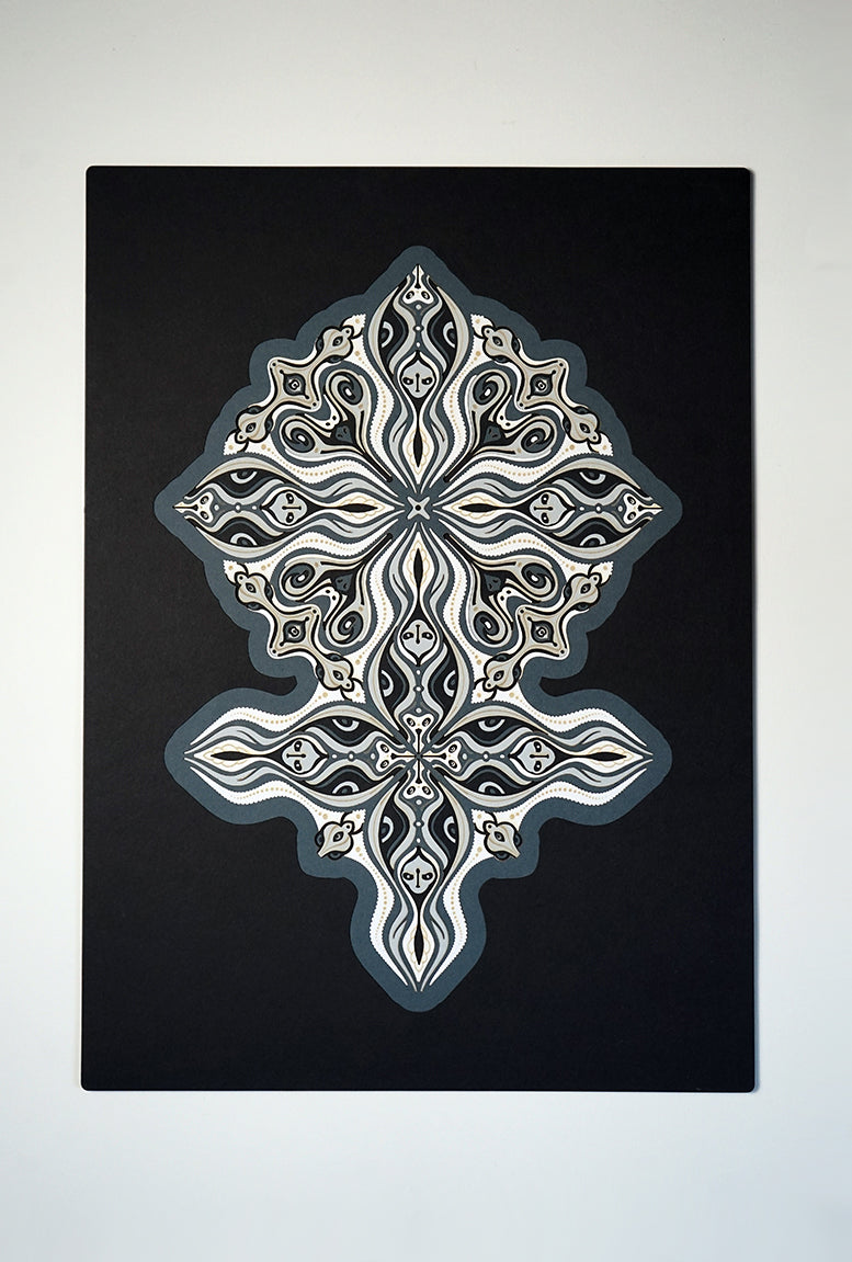Layered grayscale paper forming symmetrical mandala patterns that reveal subtle, mask-like faces from the Metamorphs series