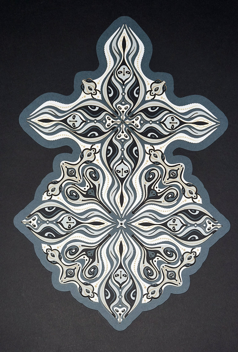 Layered grayscale paper forming symmetrical mandala patterns that reveal subtle, mask-like faces from the Metamorphs series