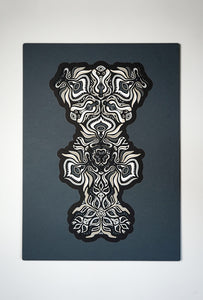 Black and white layered paper mandala with emerging animal spirit faces, part of the Metamorphs collection.