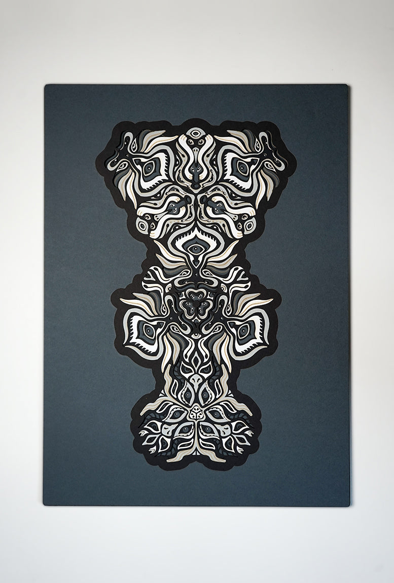 Black and white layered paper mandala with emerging animal spirit faces, part of the Metamorphs collection.