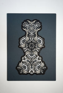 Black and white layered paper mandala with emerging animal spirit faces, part of the Metamorphs collection.