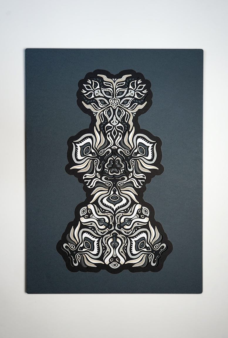 Black and white layered paper mandala with emerging animal spirit faces, part of the Metamorphs collection.
