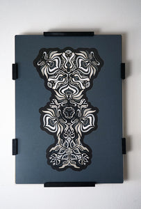 Black and white layered paper mandala with emerging animal spirit faces, part of the Metamorphs collection.