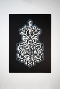 Complex black and white paper layers forming interconnected mandalas that hide subtle morphing faces.