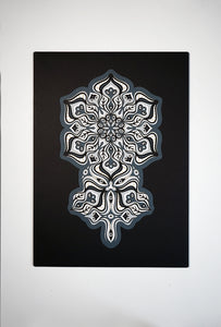 Complex black and white paper layers forming interconnected mandalas that hide subtle morphing faces.