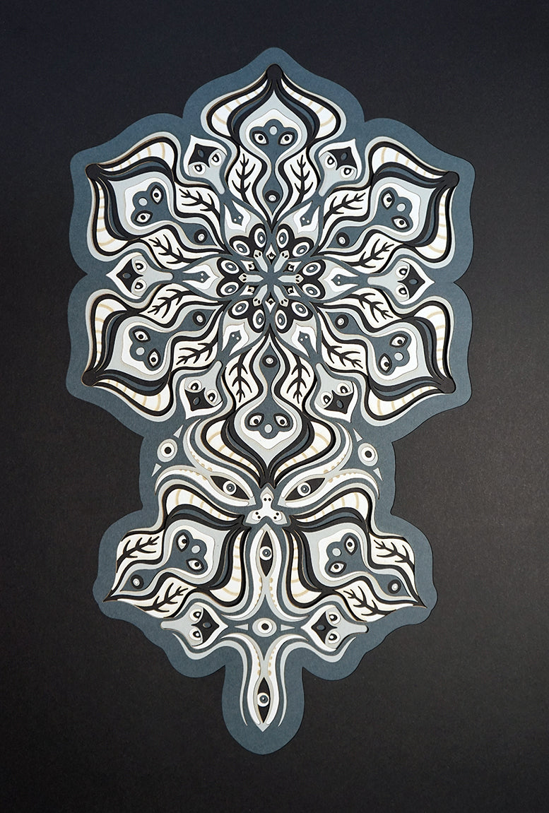 Complex black and white paper layers forming interconnected mandalas that hide subtle morphing faces.