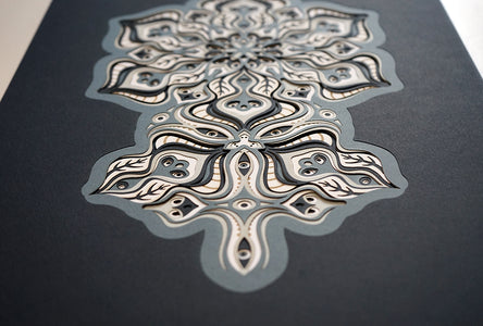 Complex black and white paper layers forming interconnected mandalas that hide subtle morphing faces.