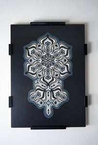 Complex black and white paper layers forming interconnected mandalas that hide subtle morphing faces.