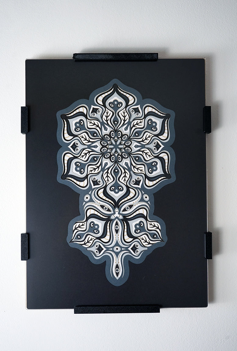 Complex black and white paper layers forming interconnected mandalas that hide subtle morphing faces.