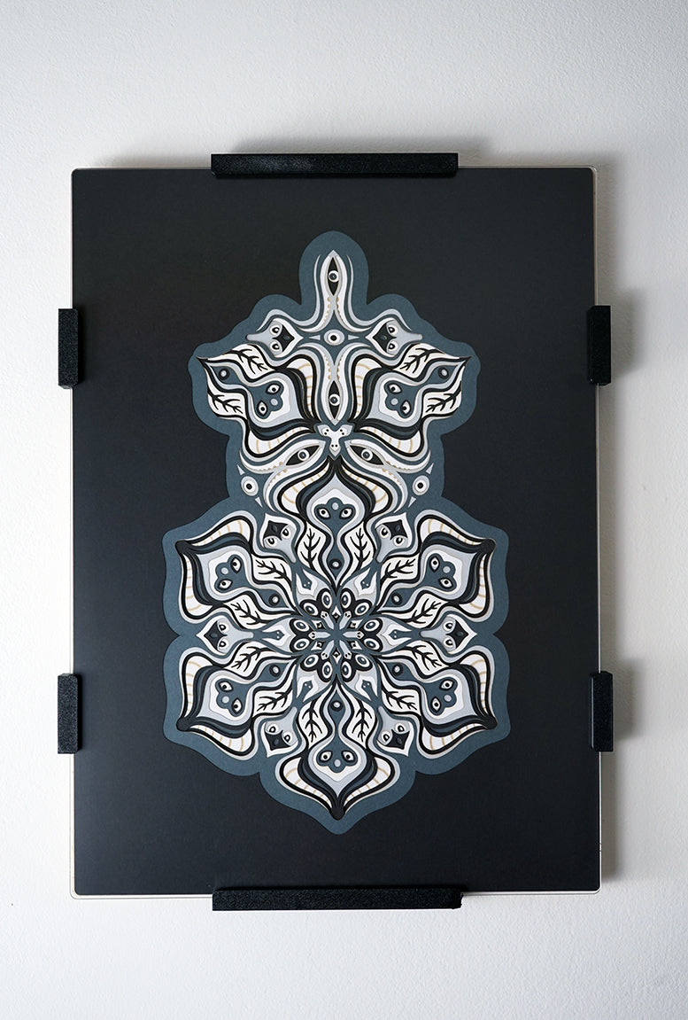 Complex black and white paper layers forming interconnected mandalas that hide subtle morphing faces.