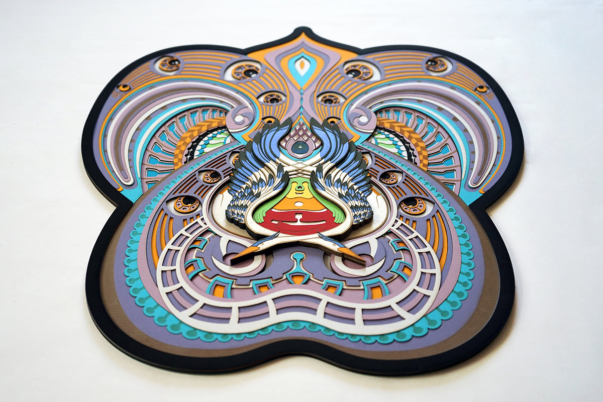 Visionary papercut artwork of a meditating figure with chakras and herons, representing oneness, enlightenment, and cosmic flow.