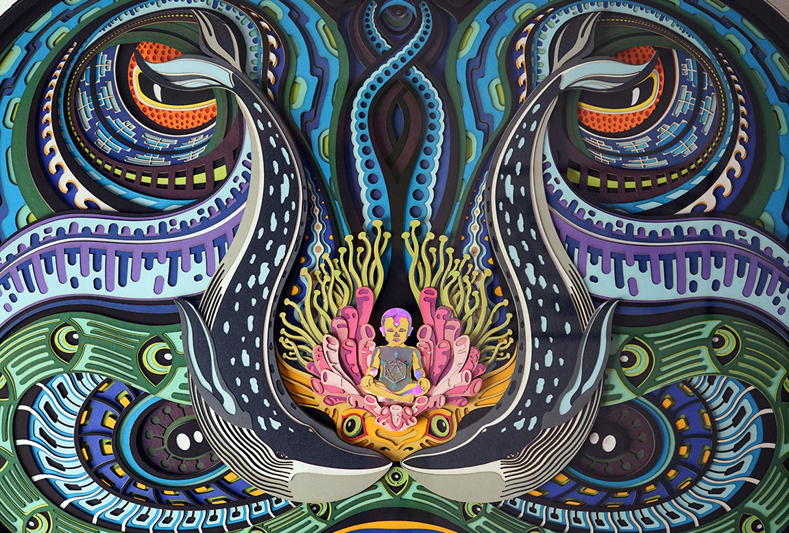 Layered paper art of infant on coral throne with whales and ocean patterns, symbolizing life’s origin and unity.