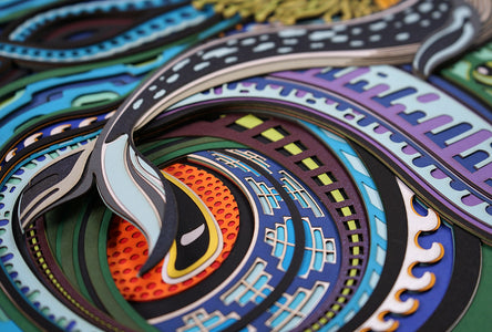 Layered paper art of infant on coral throne with whales and ocean patterns, symbolizing life’s origin and unity.