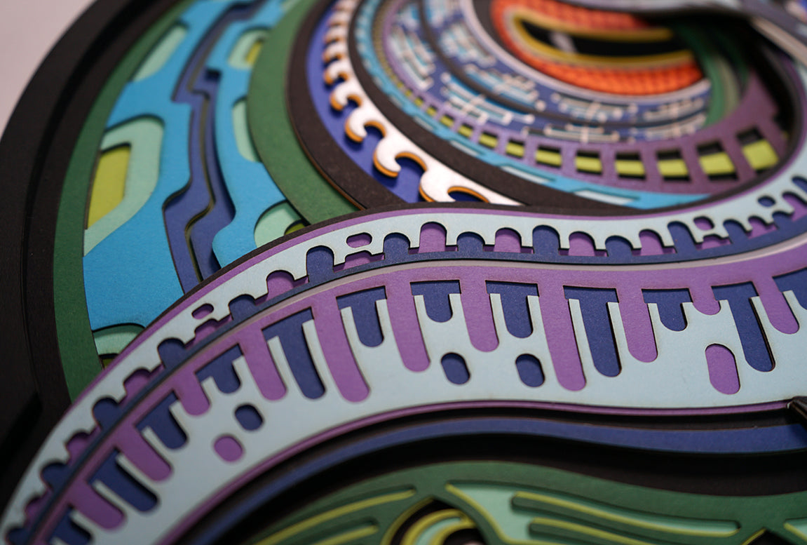 Layered paper art of infant on coral throne with whales and ocean patterns, symbolizing life’s origin and unity.