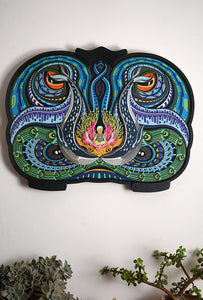 Layered paper art of infant on coral throne with whales and ocean patterns, symbolizing life’s origin and unity.