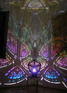 A colorful shadow lamp with a three-petal flower design, projecting vibrant rainbow shadows on the wall