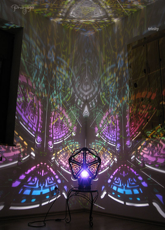 A colorful shadow lamp with a three-petal flower design, projecting vibrant rainbow shadows on the wall