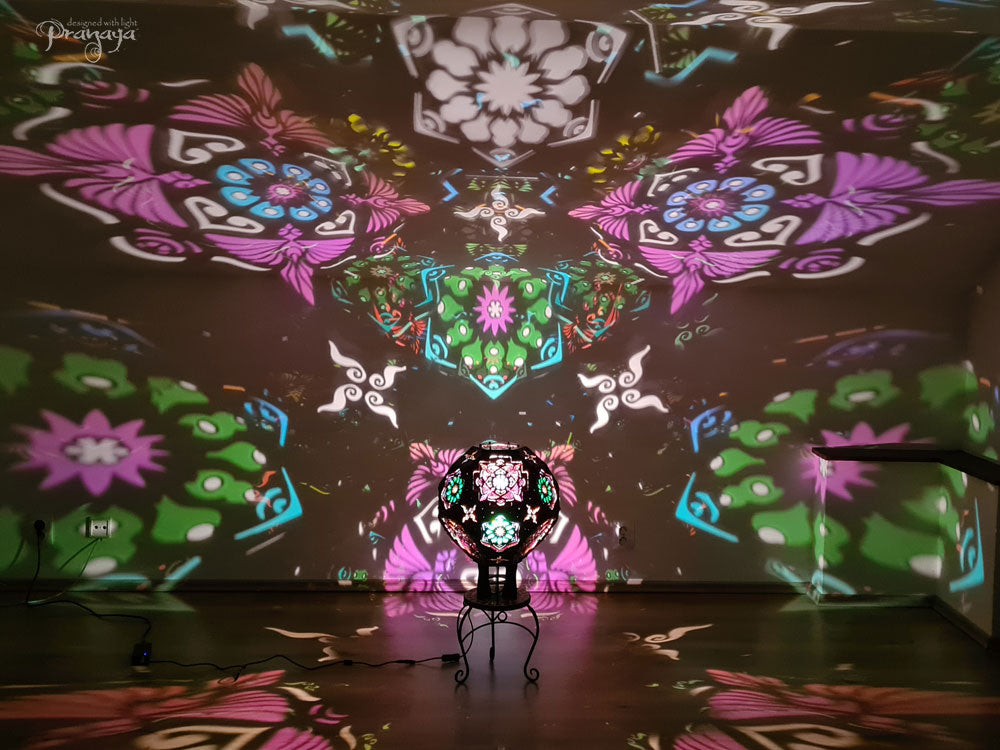 A psychedelic geometric shadow lamp projecting colorful cactus mandalas on the walls