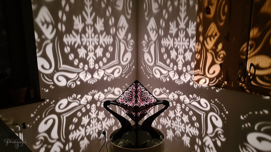 Octahedron wooden shadow lamp projecting a geometric pattern on a wall.