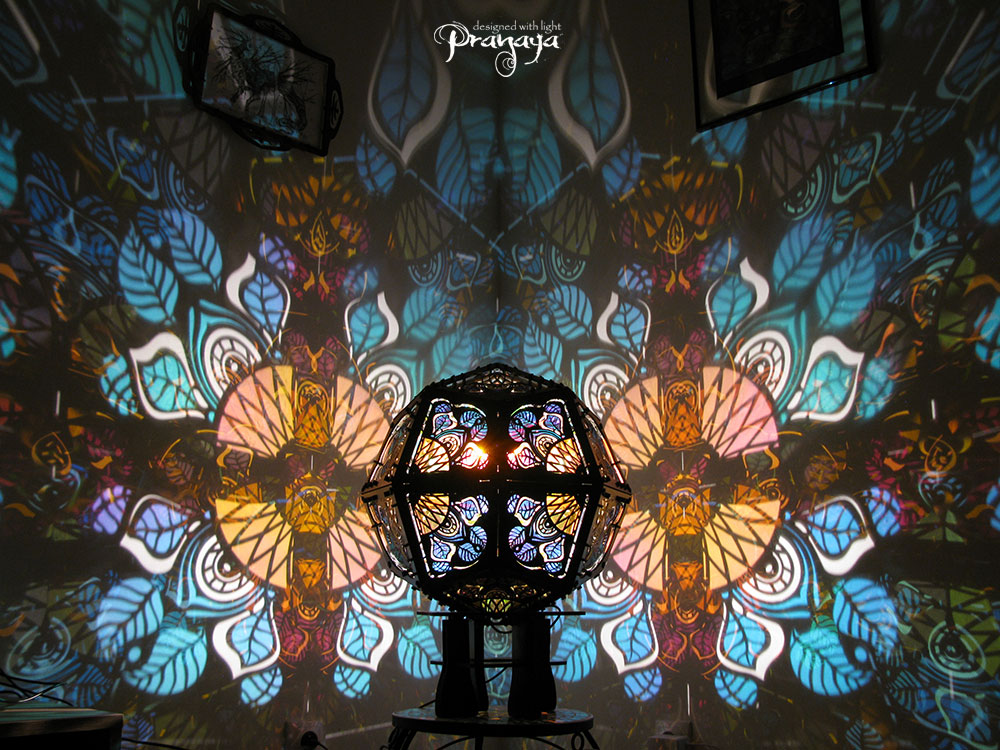 Geometric shadow lamp that projects colorful iridescent mandalas with leaves on the wall
