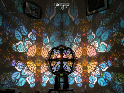 Geometric shadow lamp that projects colorful iridescent mandalas with leaves on the wall