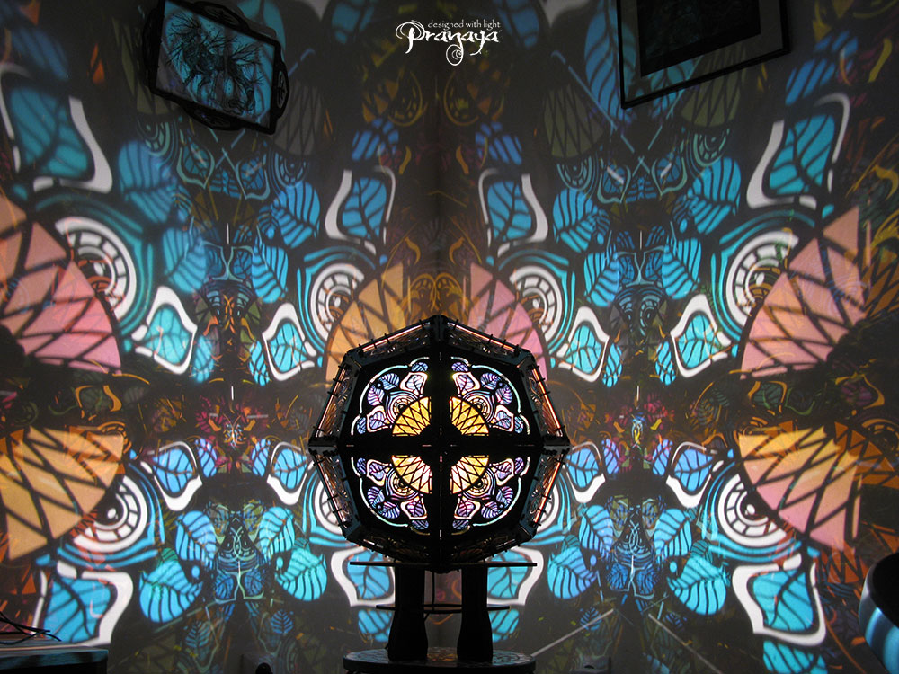 Geometric shadow lamp that projects colorful iridescent mandalas with leaves on the wall