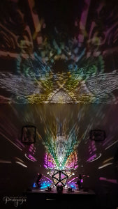 A colorful shadow lamp with a three-petal flower design, projecting vibrant rainbow shadows on the wall