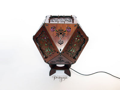 A colorful kaleidoscopic shadow lamp with a geometric pattern, showcasing a cuboctahedron shape with intricate cut-outs, mounted on a stand.