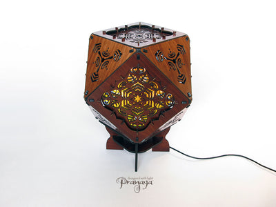 A colorful kaleidoscopic shadow lamp with a geometric pattern, showcasing a cuboctahedron shape with intricate cut-outs, mounted on a stand.